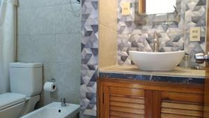 a bathroom with a sink and a toilet at Remanso Apart Hotel in Termas del Daymán