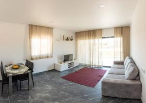 ein Wohnzimmer mit einem Sofa und einem Tisch in der Unterkunft Sunset House in Vila do Bispo