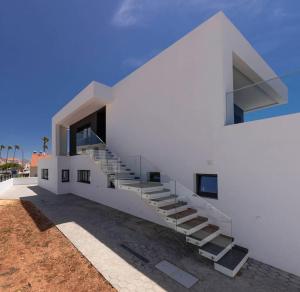 een wit gebouw met trappen aan de zijkant bij Sunset House in Vila do Bispo