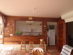 a kitchen with wooden walls and a table and chairs at villa bois style créole in Le Robert