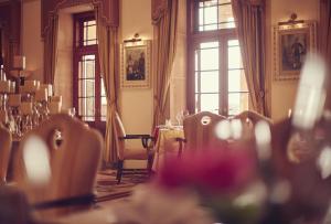 a room with a table and chairs and windows at Umaid Bhawan Palace Jodhpur in Jodhpur