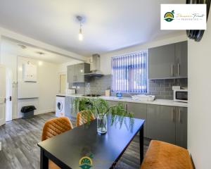 a kitchen with a table and chairs in a room at 3 Bedroom Coventry House By Passionfruitproperties with Free Wi-fi, Large Garden and Driveway - 52NRC in Coventry