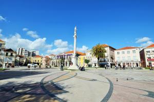 a square with a monument in the middle of a city at Suites DP Setúbal in Setúbal
