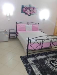 a bedroom with a bed with pink and white sheets at Rincon d'Alicia in Dakar