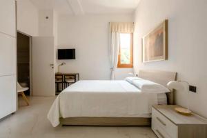 - une chambre blanche avec un grand lit et une fenêtre dans l'établissement Appartamento il Mugnaio, à Bologne