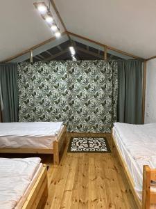 DzhetyoguzにあるEco Village Lodgeのベッド2台が備わる壁の客室です。