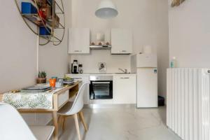 - une cuisine blanche avec une table et un réfrigérateur dans l'établissement Appartamento il Mugnaio, à Bologne