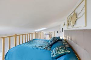 uma cama com lençóis e almofadas azuis em L'élégante maisonnette - T2 - paris - Orly - RER C em Vitry-sur-Seine
