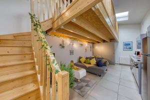 sala de estar con escaleras de madera y sofá en L'élégante maisonnette - T2 - paris - Orly - RER C en Vitry-sur-Seine