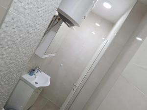 a white bathroom with a toilet and a sink at Apartman Platan in Trebinje