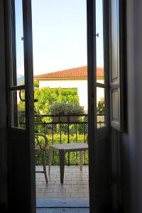 マリーナ・ディ・ピエトラサンタにあるHotel Le Giareのバルコニーにベンチ付きのオープンドア