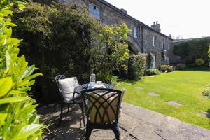 a table and chairs in a garden with a building at Character Cottage In West Burton, Wensleydale in West Burton