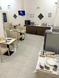 una sala da pranzo con tavoli, sedie e bancone di Hotel La Plancia a Otranto
