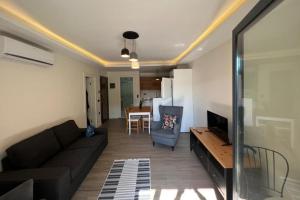 ein Wohnzimmer mit einem schwarzen Sofa und einem Tisch in der Unterkunft Enoya Suites Ilıca in Cesme