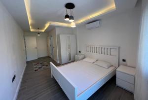 een slaapkamer met een groot wit bed in een kamer bij Enoya Suites Ilıca in Çeşme