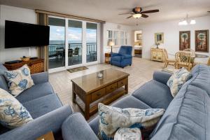 sala de estar con sofás azules y TV de pantalla plana en Nautilus 1702 Gulf Front Large 2 Bedroom Penthouse 7th Floor en Fort Walton Beach