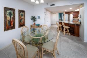 uma sala de jantar e cozinha com uma mesa de vidro e cadeiras em Nautilus 1702 Gulf Front Large 2 Bedroom Penthouse 7th Floor em Fort Walton Beach
