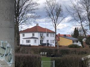 a large white house with a red roof at Sundkig fra 1. Sal in Svendborg