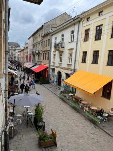 uma rua com mesas e guarda-sóis numa cidade em Cozy Loft на Староєврейській 24 em Lviv