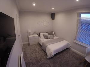 En eller flere senge i et værelse på Essex House 3 Bedrooms Workstays UK
