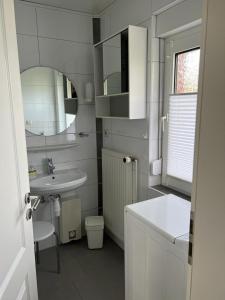uma casa de banho branca com um lavatório e um WC em Haus Juist-Norddeich em Norden