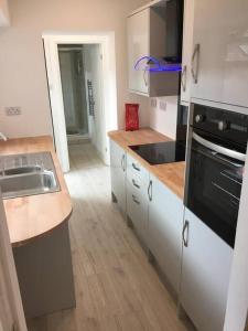 a kitchen with a sink and a stove top oven at Falmouth House 3 Bedrooms 5 Beds Workstays UK in Middlesbrough