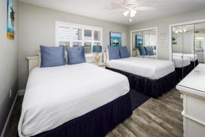 Nautilus 2409 Gulf View 2 Bedroom 4th Floor Free Beach Service في شاطئ فورت والتون: سريرين في غرفة مع وسائد زرقاء
