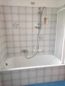 a bath tub with a shower in a bathroom at Villetta con giardino in Camugnano