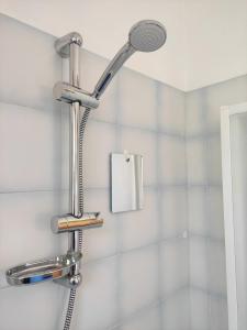 a shower with a shower head in a bathroom at Villetta con giardino in Camugnano