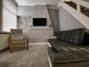 ein Wohnzimmer mit einem Sofa und einem TV in der Unterkunft Haddon House Workstays UK in Middlesbrough