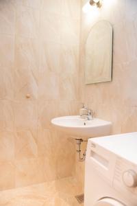 a bathroom with a sink and a toilet and a mirror at Green Life Beach Resort Apartment in Sozopol