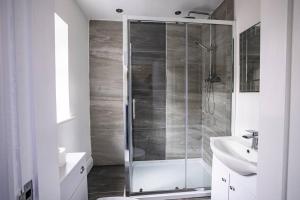 a bathroom with a glass shower and a sink at Roscoe House 4 Bedrooms Workstays UK in Middlesbrough