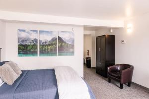 ein Schlafzimmer mit einem Bett, einem Stuhl und Bergen in der Unterkunft Alaska Frontier Inn in Delta Junction