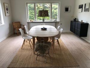 a dining room with a wooden table and chairs at Sundkig fra 1. Sal in Svendborg