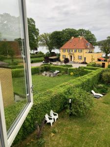 a window with a view of a house and a yard at Sundkig fra 1. Sal in Svendborg