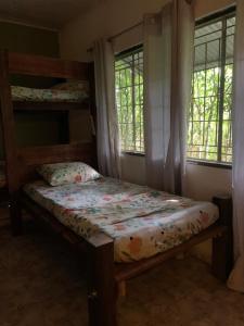 a bedroom with two bunk beds and two windows at Nomada Hostel in Leticia