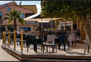 a patio with chairs and tables and umbrellas at Dream holidays in Valras-Plage