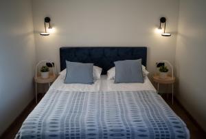 1 Schlafzimmer mit einem blauen Bett und 2 Tischen in der Unterkunft Karwia Marina Apartamenty in Karwia