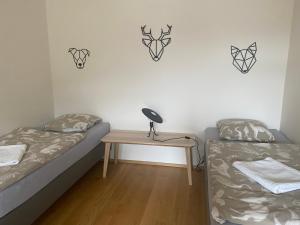 1 dormitorio con 2 camas y escritorio con lámpara en Luxusní Apartmán u sjezdovek s garáží en Harrachov