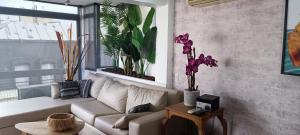 una sala de estar con un sofá blanco y algunas plantas en Apartamento Valentin Gomez en Buenos Aires