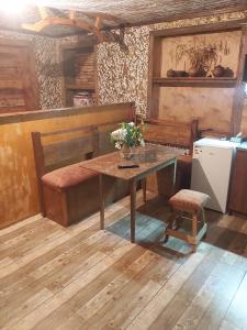 a room with a wooden table and a bench and a table and chair at Xrchit (Խրճիթ) in Gyumri