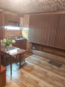eine Küche mit einem Holztisch und Holzböden in der Unterkunft Xrchit (Խրճիթ) in Gjumri
