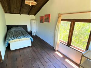 1 dormitorio con cama y ventana grande en Peña de Horeb, en Villa Serrana