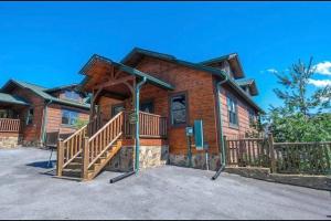 a log cabin with a large front porch and stairs at Cabin With Stunning Views, Hot Tub, Game Room in Gatlinburg
