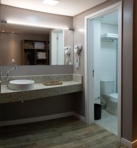 a bathroom with a sink and a mirror at Comfort Hotel Maceió in Maceió
