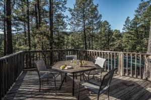 a patio with a table and chairs on a deck at Cuddle Up in Ruidoso