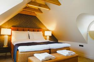 a bedroom with a bed with two towels on a stool at Meerbach Residents in Kuressaare