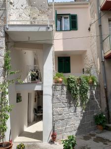 una vista exterior de un edificio con persianas verdes en Karmelita's place -studio, en Šibenik