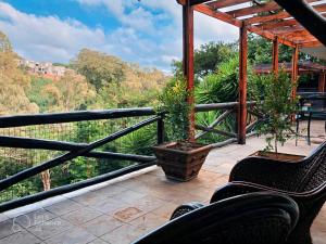 a balcony with chairs and a view of trees at PRETORIA MANSION Boutique Hotel in Pretoria