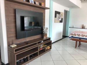 una sala de estar con TV en un centro de entretenimiento de madera en Casa Sérgio, en Itajaí